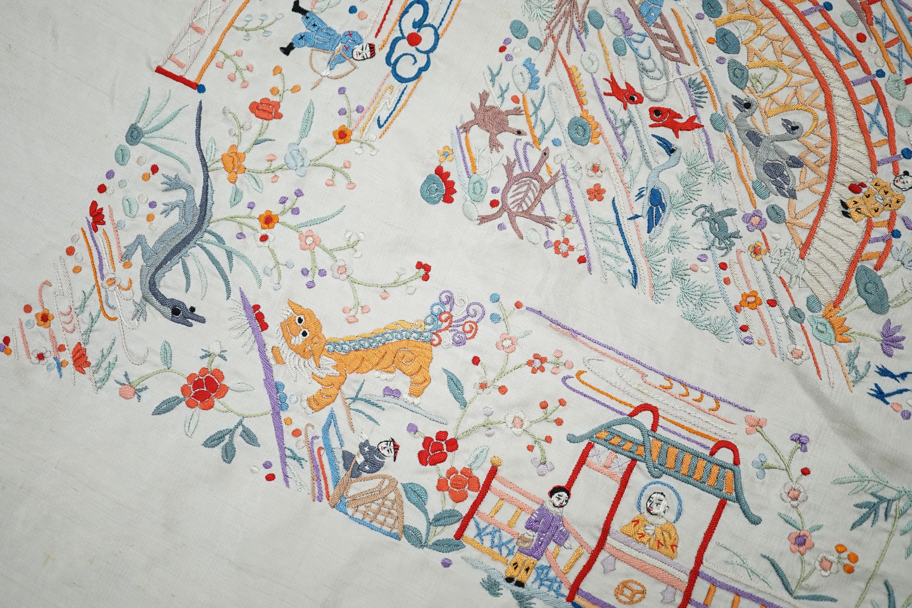 A Chinese cream silk shawl with fine multi coloured all over embroidery depicting figurative scenes and animals